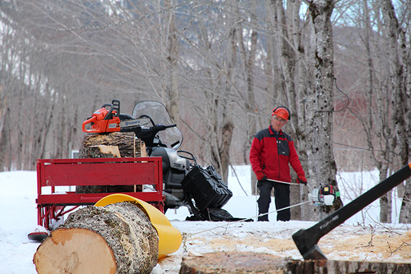 Uomo che utilizza un verricello PCW3000 per trainare un tronco di grandi dimensioni.